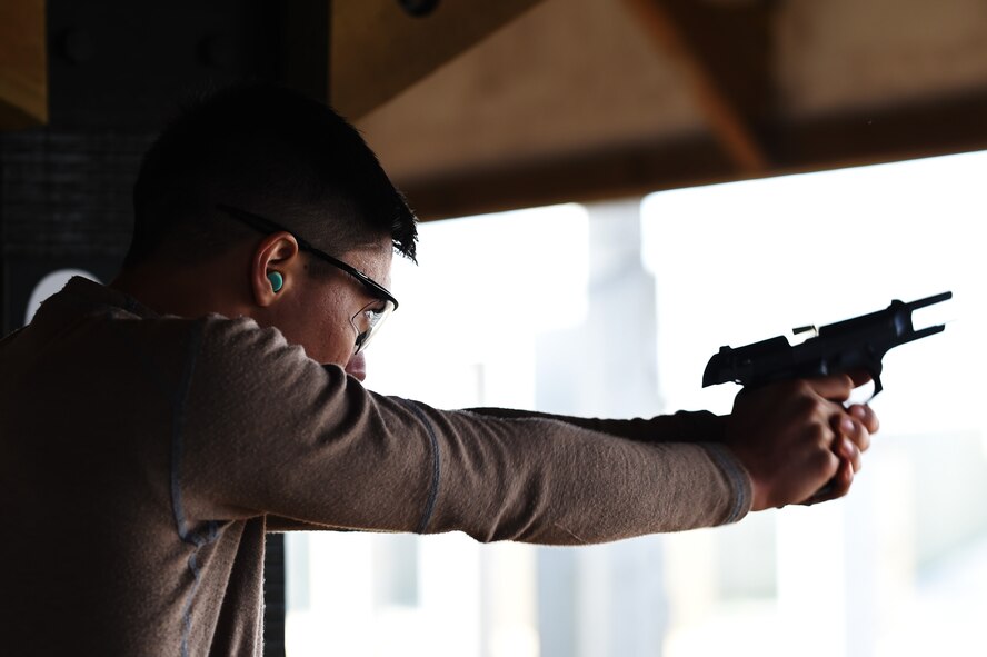 Senior Airman Kevin Sekishiro, 423rd Security Forces Squadron patrolman, fires a round from an M9 pistol during a National Police Week shooting competition at RAF Molesworth, England, May 13, 2015. Police Week was established to honor law enforcement officers who gave their lives in the line of duty. (U.S. Air Force photo by Staff Sgt. Jarad A. Denton/Released)