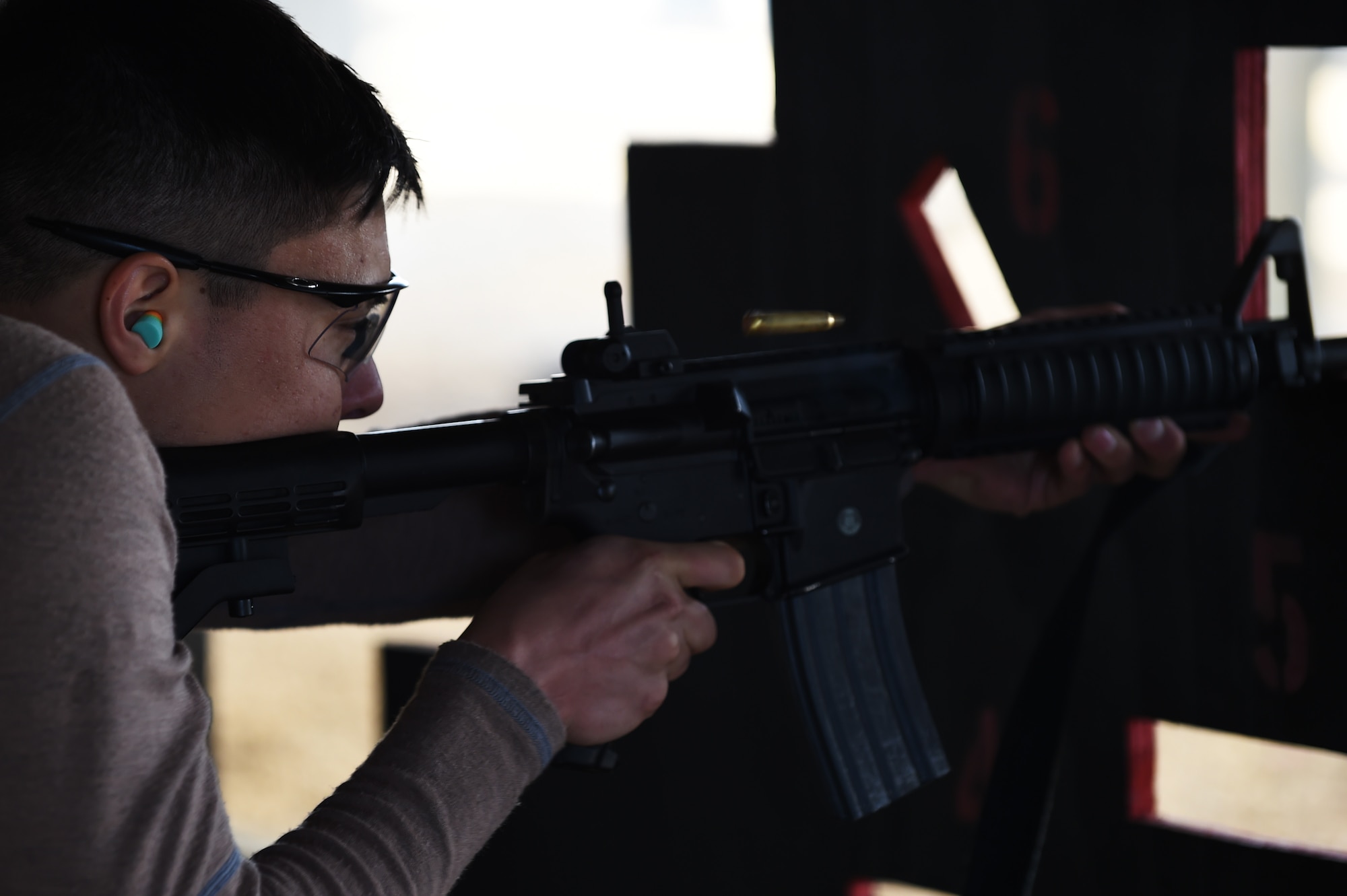 Senior Airman Kevin Sekishiro, 423rd Security Forces Squadron patrolman, fires a round from an M4 carbine during a shooting competition at RAF Molesworth, England, May 13, 2015. Sekishiro participated in the competition to support National Police Week. (U.S. Air Force photo by Staff Sgt. Jarad A. Denton/Released)