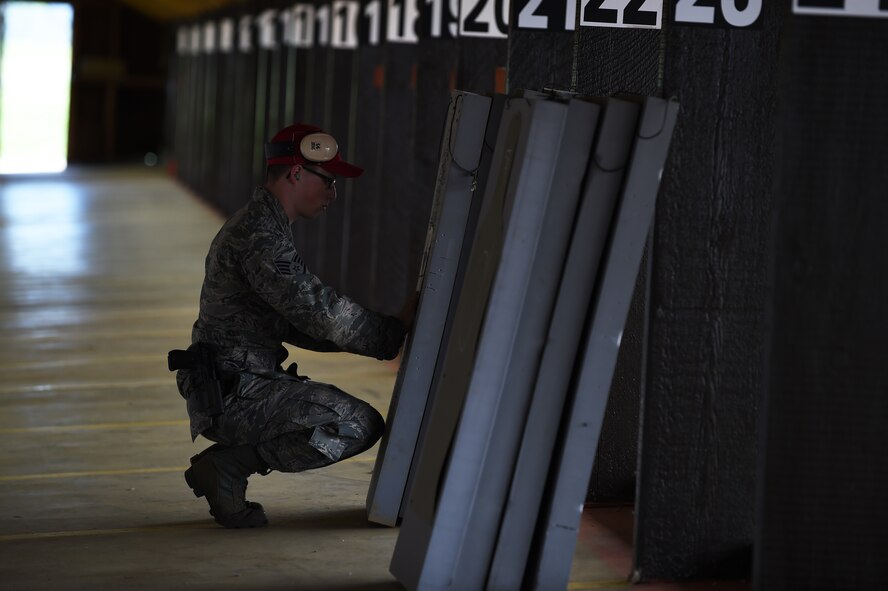 Staff Sgt. Christian Gosselin, 423rd Security Forces Squadron combat arms training and maintenance instructor, sets up targets prior to a shooting competition during National Police Week at RAF Molesworth, England, May 13, 2015. Service members and civilians across the 501st Combat Support Wing came together during Police Week to honor law enforcement officers who gave their lives in the line of duty. (U.S. Air Force photo by Staff Sgt. Jarad A. Denton/Released)