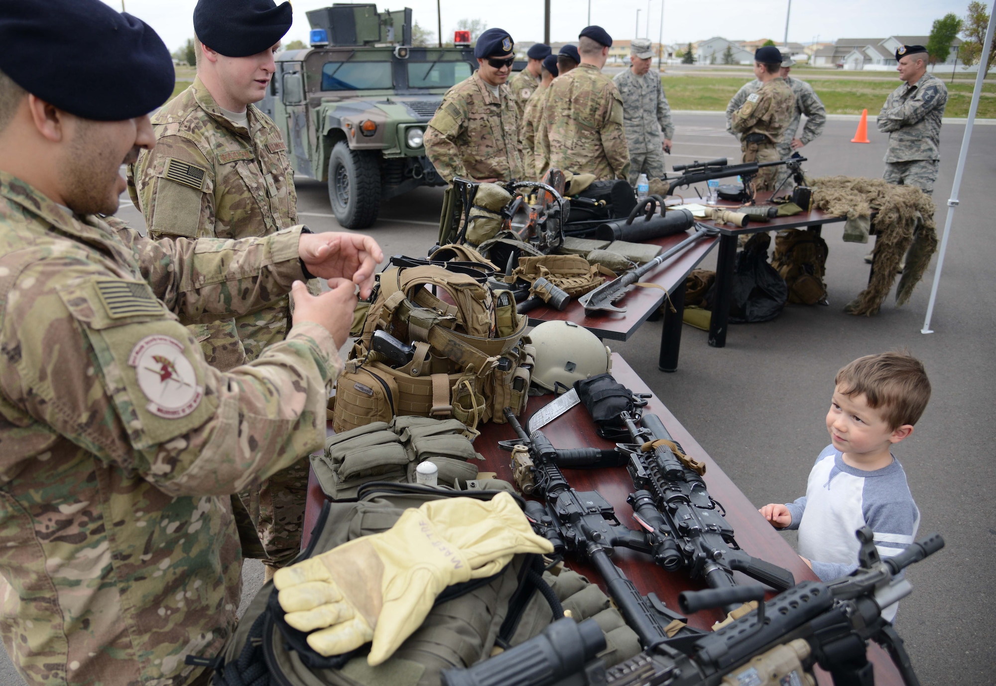 J.D. Monroe V, right, 4, son of Tech. Sgt. J.D. Monroe IV, 341st Missile Security Forces Squadron assistant flight chief, learns about the weapons used by security forces members during a police week demonstration May 13, 2015, at Malmstrom Air Force Base, Mont. Various security forces agencies came out to showcase their unique capabilities. (U.S. Air Force photo/Airman 1st Class Dillon Johnston)
