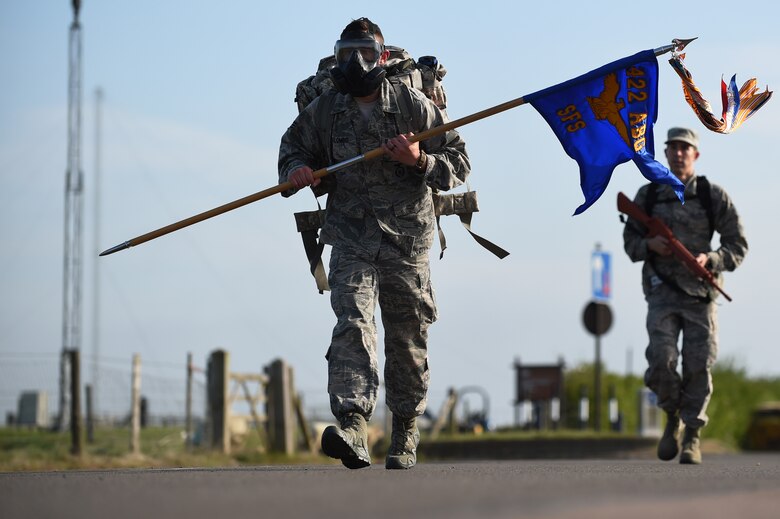 Senior Airman James Colombo, 422nd Security Forces Squadron unit trainer, jogs along the perimeter road at RAF Croughton, England, May 11, 2015, while carrying a guidon and wearing a gas mask, during a ruck march in honor of National Police Week. Colombo said he carried the extra gear to show his support for law enforcement officers who gave their lives in the line of duty. (U.S. Air Force photo by Staff Sgt. Jarad A. Denton/Released)