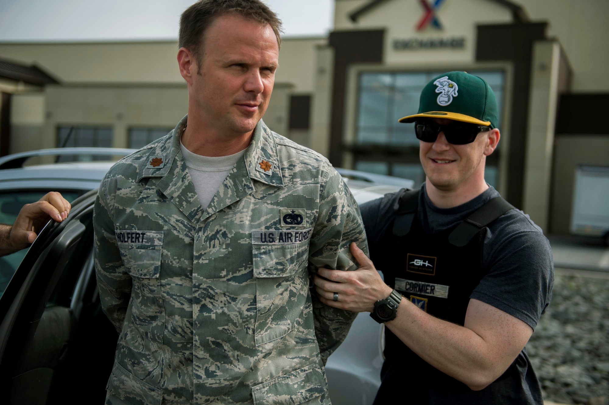 U.S. Air Force Maj. Lee Holfert, a 52nd Logistics Readiness Squadron operations officer, left, steps out of a vehicle while in custody of U.S. Air Force Staff Sgt. Matthew Cormier, a 52nd Security Forces Squadron training instructor, during the National Police Week Jail and Bail event at the Exchange on Spangdahlem Air Base, Germany, May 12, 2015. Participants of the event could pay more than the minimum amount of $5 to jail people for a longer period of time. (U.S. Air Force photo by Airman 1st Class Timothy Kim/Released)