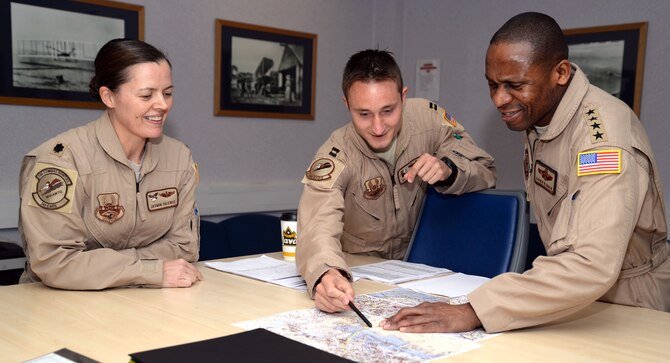 U.S. Air Force Gen. Darren W. McDew, right, Air Mobility Command commander, goes over a flight plan with aircrew members April 22, 2015, on RAF Mildenhall, England. McDew visited RAF Mildenhall for a day, meeting Airmen from different squadrons and learning first-hand how Team Mildenhall refuels the fight. (U.S. Air Force Photo by Senior Airman Christine Halan/Released)