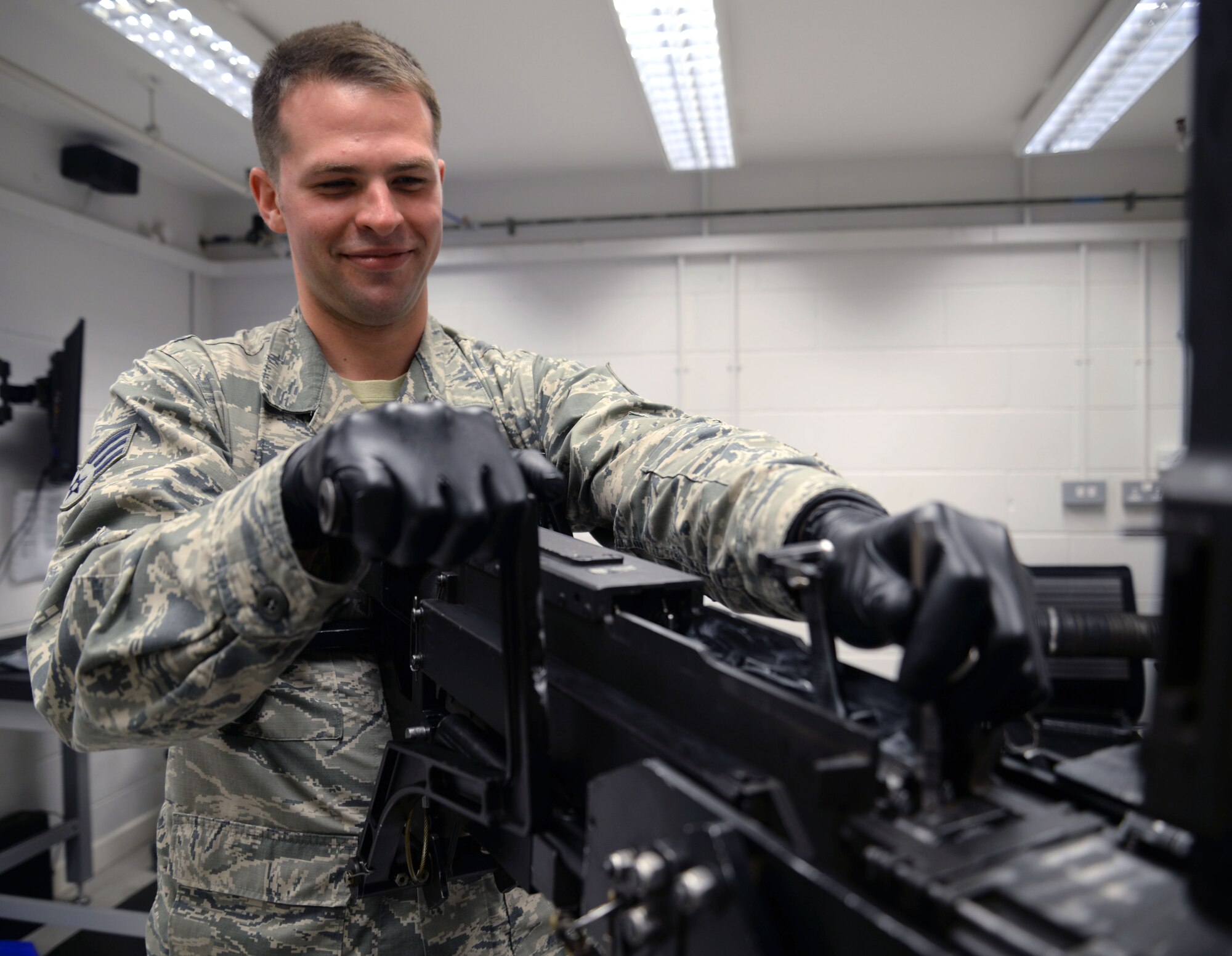 U.S. Air Force Senior Airman Charles M. McDermott, 352nd Special Operations Maintenance Squadron CV-22 Weapons Systems journeyman from Oklahoma City, conducts a barrel erosion check on a .50 caliber GAU-21 machine gun May 7, 2015, on RAF Mildenhall, England. McDermott was awarded the Square D Spotlight for displaying the core value of “Excellence in All We Do.” (U.S. Air Force photo by Senior Airman Christine Halan/Released) 
