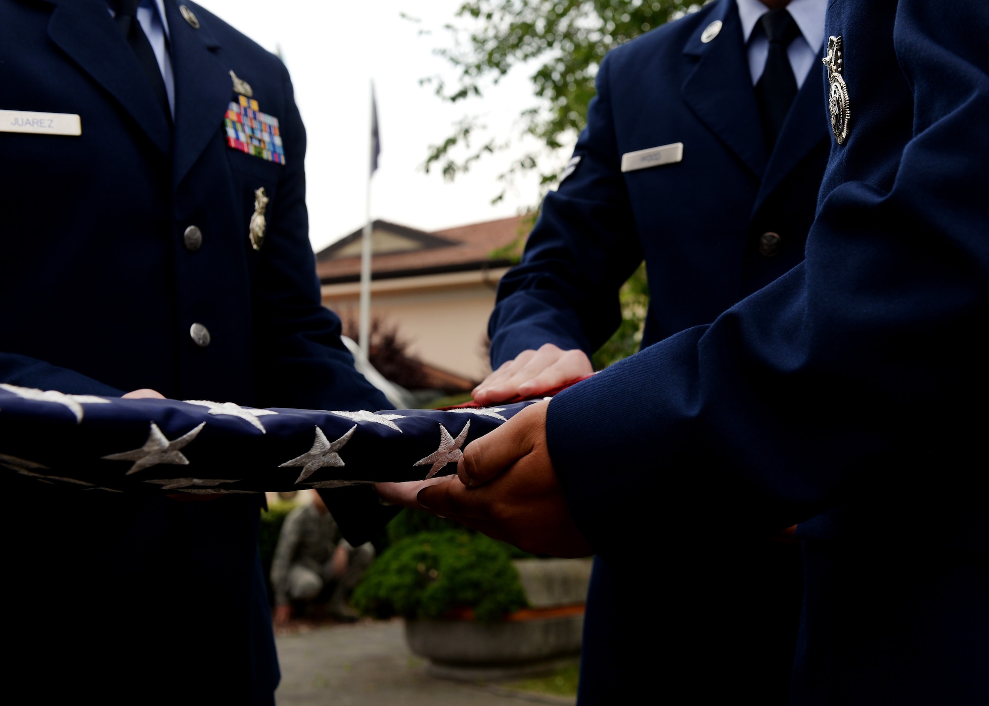 U.S. Air Force Airmen fold the flag at the Police Week retreat ceremony, May 14, 2015, at Aviano Air Base, Italy.  During the week, ceremonies, memorials and other events took place to honor the men and women who have served in the line of duty. (U.S. Air Force photo by Airman 1st Class Cary Smith/Released)