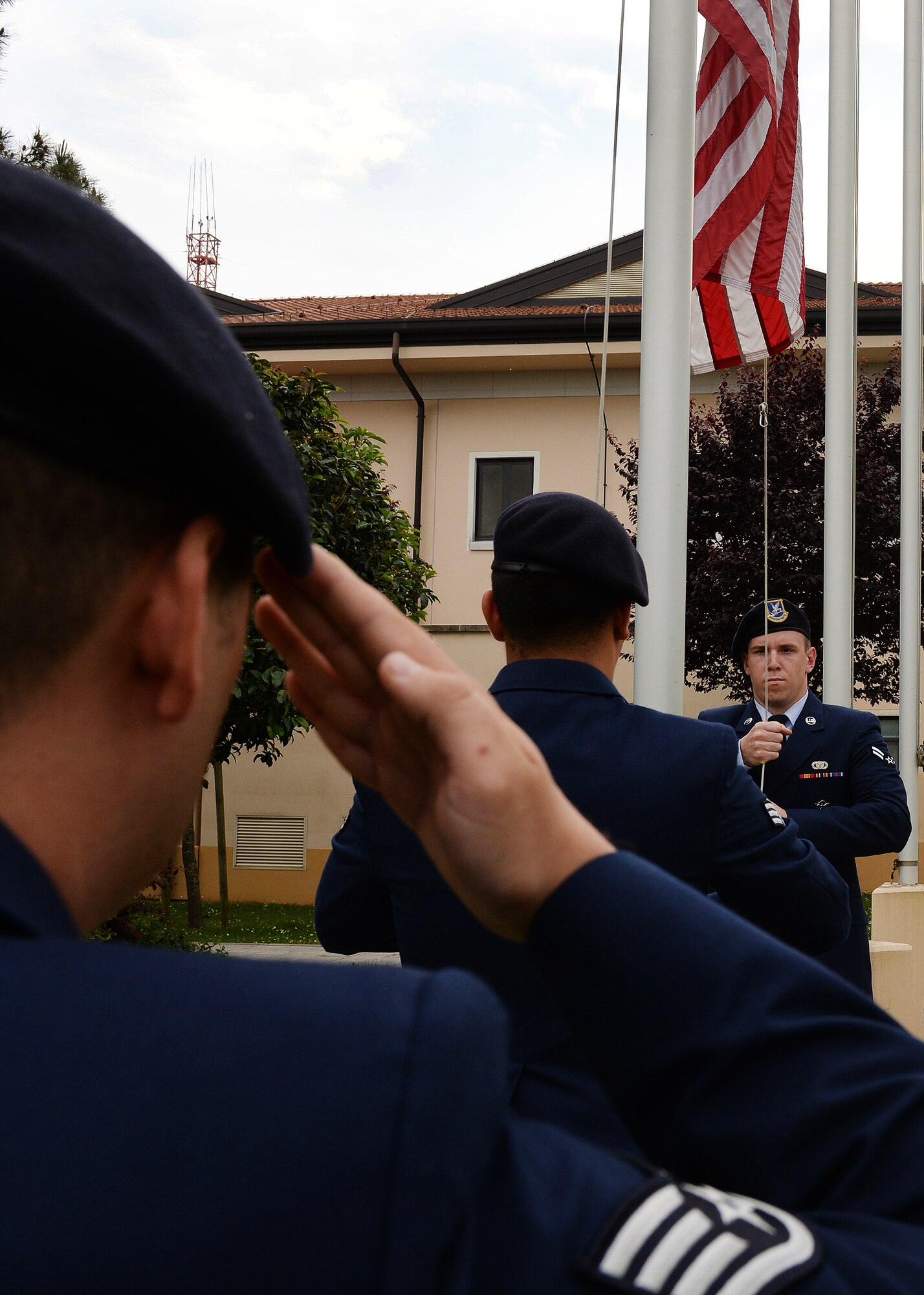 U.S. Air Force Airmen lower the flag at the Police Week retreat ceremony, May 14, 2015, at Aviano Air Base, Italy.  During the week, ceremonies, memorials and other events took place to honor the men and women who have served in the line of duty. (U.S. Air Force photo by Airman 1st Class Cary Smith/Released)