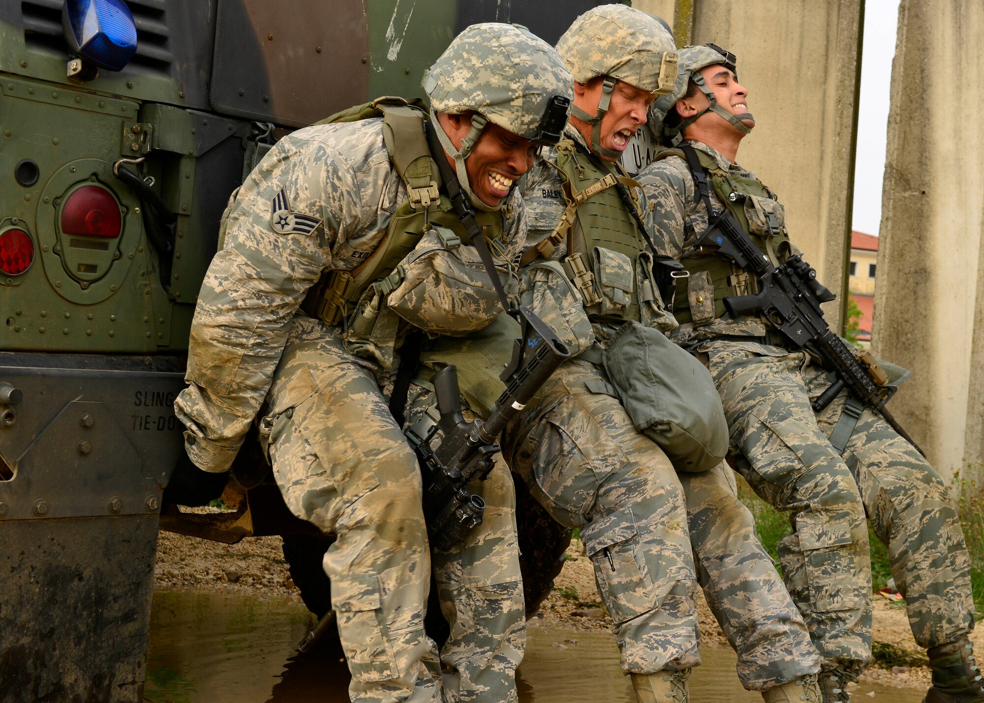 U.S. Air Force defenders push a Humvee out during the Security Forces Squadron Fire Team Challenge during Police Week, May 13, 2015, at Aviano Air Base, Italy.  The Humvee push was one of 12 stations set up to test mental and physical strength.   During the week, ceremonies, memorials and other events took place to honor the men and women who have served in the line of duty. (U.S. Air Force photo by Airman 1st Class Cary Smith/Released)