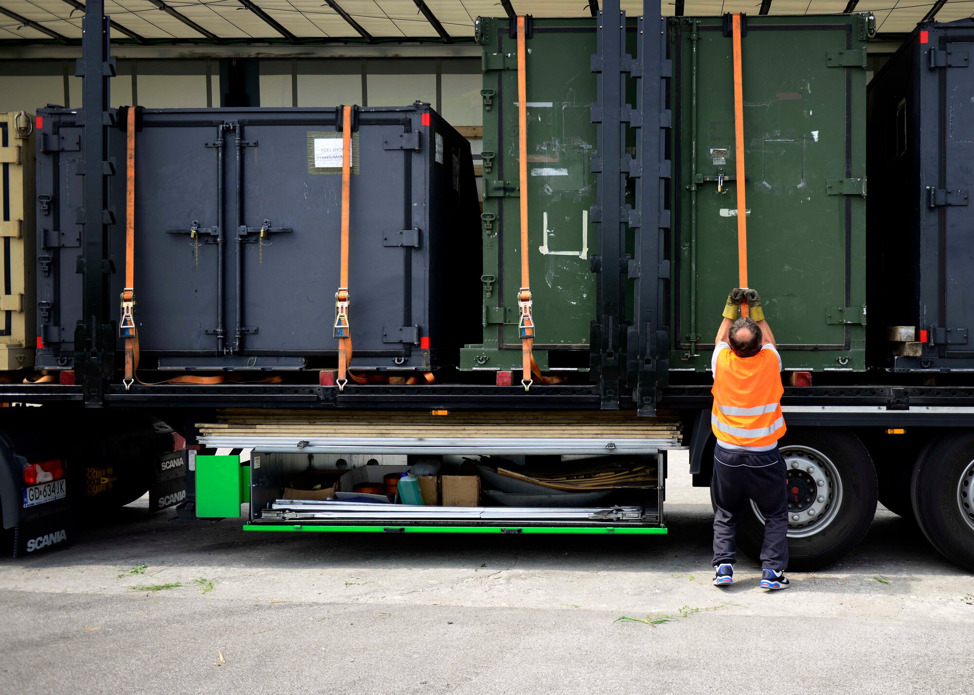 A contractor straps cargo, May 12, 2015, at Aviano Air Base, Italy. Airmen and contractors with the 31st Logistics Readiness Squadron traffic management office prepare items for shipping to temporary duty locations and around the world. (U.S. Air Force Senior Airman Areca T. Wilson/Released)