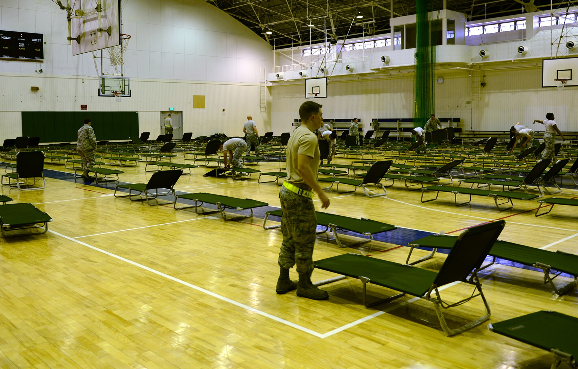 Cots are set up inside the Samurai Fitness Center by Airmen from the 374th Force Support Squadron May 15, 2015, at Yokota Air Base, Japan. FSS set up the fitness center as a temporary lodging facility to house Marines whose aircraft landed at Yokota due to maintenance issues. (U.S. Air Force photo by Senior Airman Desiree Economides/Released)