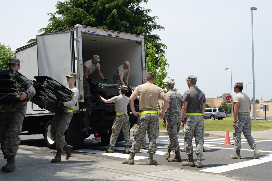 Augmentees and Airmen from the 374th Force Support Squadron unload cots at the Samurai Fitness Center May 15, 2015, at Yokota Air Base, Japan. More than 180 Marines from Heavy Helicopter Squadron 465, Marine Corps Air Station Miramar, California, utilized the fitness center as temporary lodging while they waited for maintenance to their aircraft. (U.S. Air Force photo by Senior Airman Desiree Economides/Released)