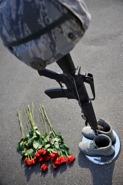 A hard helmet rests on top of an M-16, with boots and roses at its base, in remembrance of fallen defenders at Misawa Air Base, Japan, May 14, 2015. The 35th Security Forces Squadron alongside U.S. Navy and Japan Air Self-Defense Force members gathered to pay respect to those who have paid the ultimate sacrifice defending their country. (U.S. Air Force photo by Senior Airman Jose L. Hernandez-Domitilo/Released)