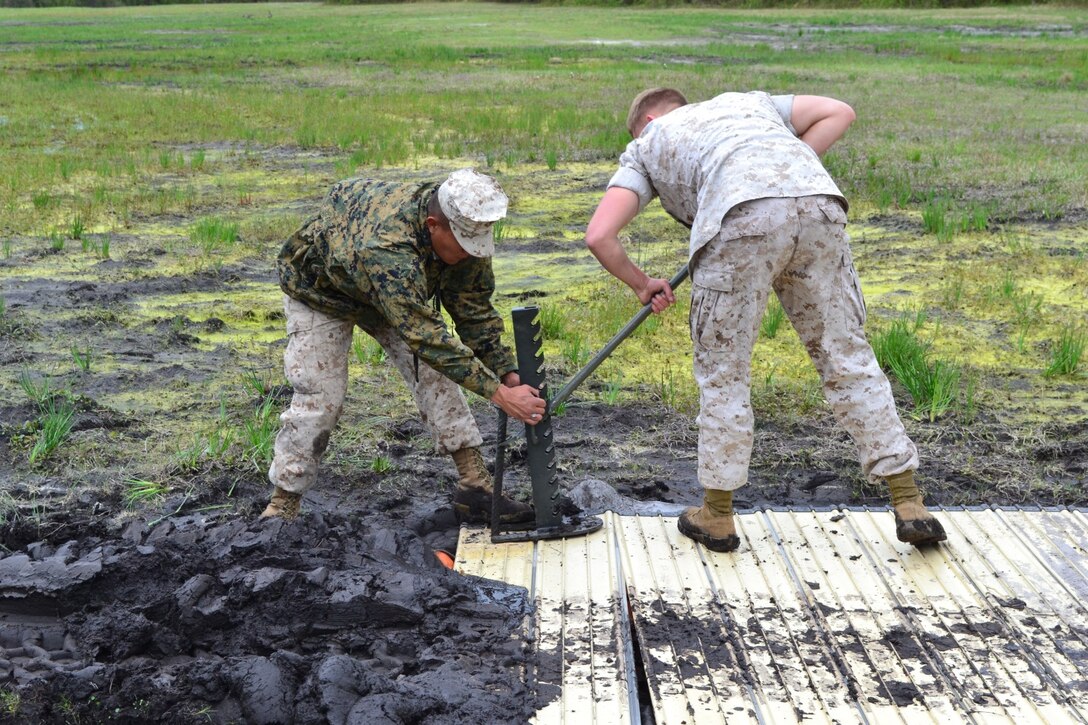 PFC Rai holds the jack while Cpl Regier manipulates the jack to retrieve an anchor.