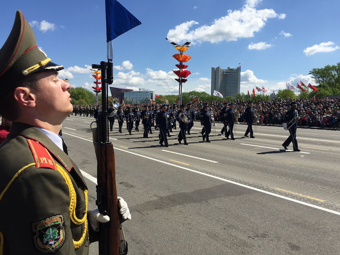 A Belarusian soldier provides an honor guard as 34 airmen from the U.S. Air Forces in Europe Band march in the World War II Victory Day Parade in Minsk, Belarus, May 9, 2015. The band's involvement is the first time that participants from the U.S. Department of Defense marched in the parade. The event commemorates the sacrifices of the World War II Allies and the end of hostilities 70 years ago. In addition to their participation in the Victory Day parade, which included more than 5,000 Belarusian and Russian soldiers and 250 military vehicles, the USAFE bandsmen performed concerts in Brest and Minsk. U.S. Air Force photo by Master Sgt. Brian Bahret