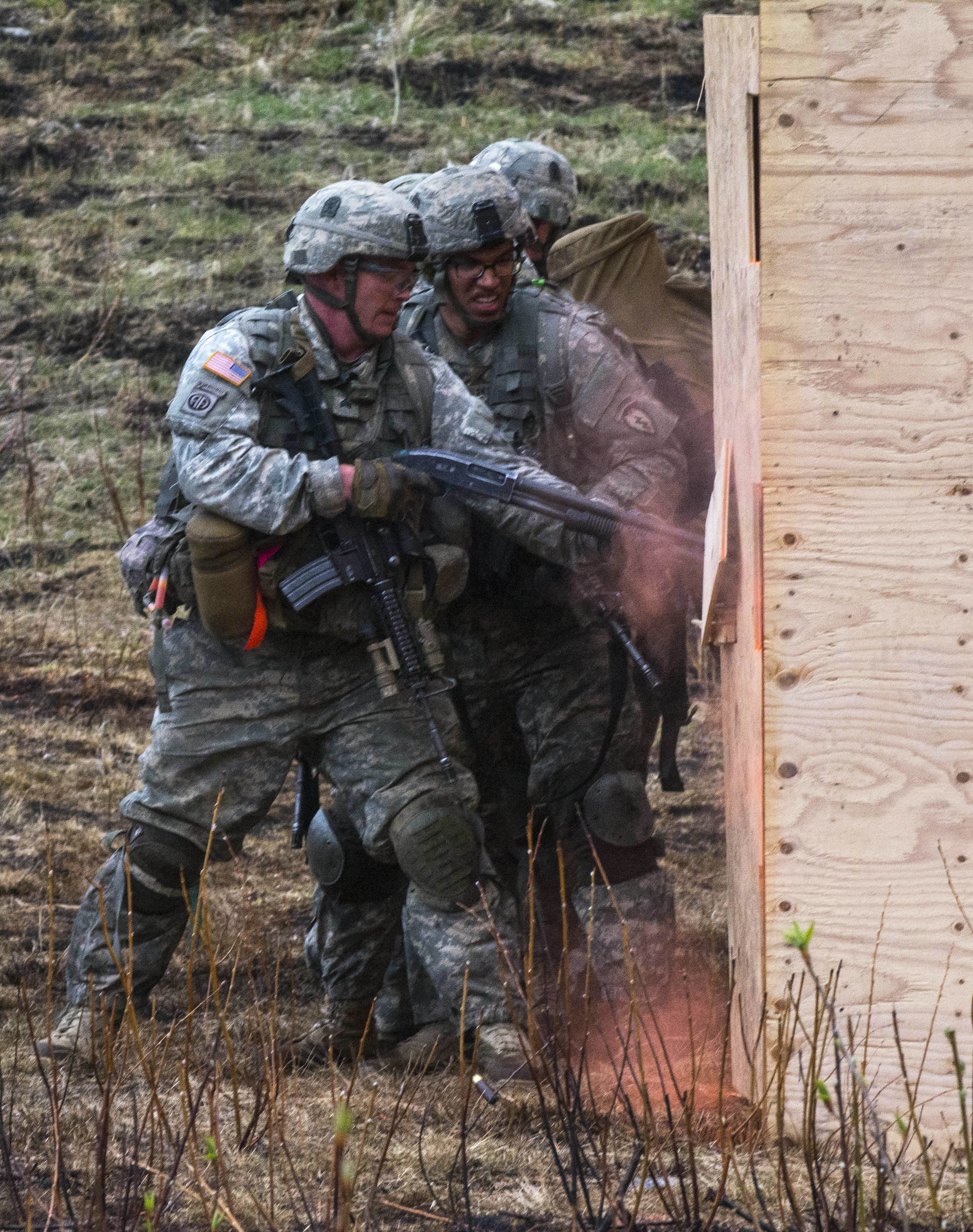 Soldiers force open a door during combined arms maneuver livefire