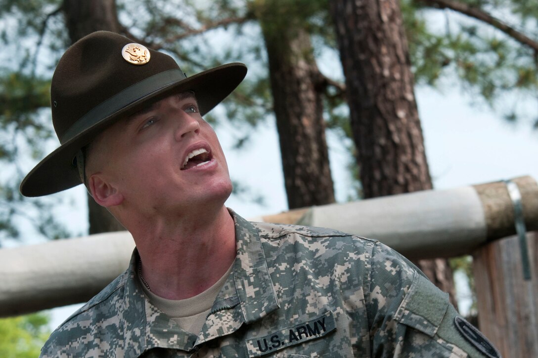 Army Sergeant Sgt. 1st Class Adam Derrick gives instruction on the proper way to navigate an obstacle for competitors in the 2015 U.S. Army Reserve Best Warrior Competition on Fort Bragg, N.C., May 6, 2015. Derrick is a drill sergeant assigned to the 397th Regiment.