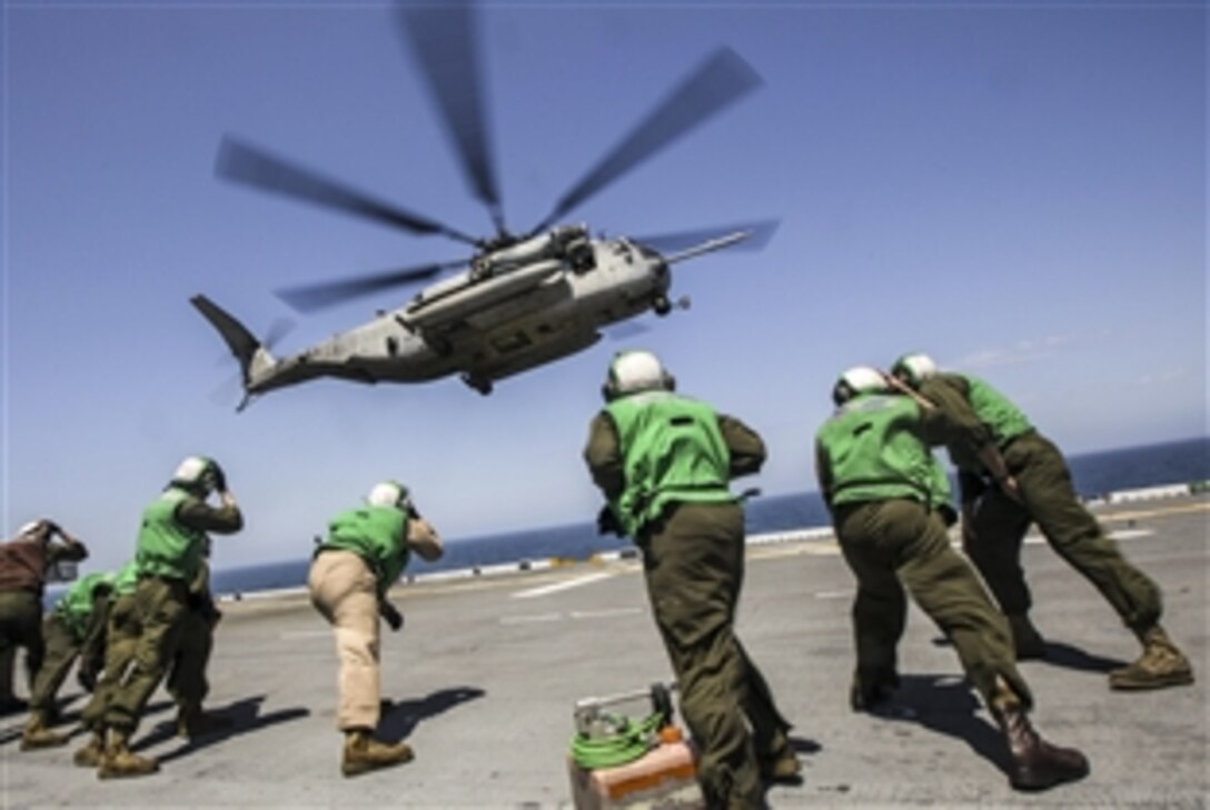 U.S. Marines brace for the rotor wash of a CH-53 Super Stallion while conducting flight operations aboard the USS Kearsarge during an integrated training event in the Atlantic Ocean, May 9, 2015. The event helps prepare the Marines, assigned to the 26th Marine Expeditionary Unit, for deployment to the areas of responsibilitly for the 5th and 6th fleets later this year.