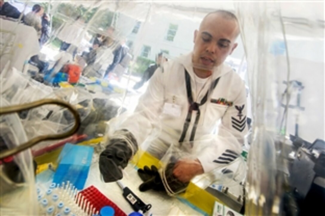 Navy Petty Officer 1st Class Mark Salvador demonstrates how to use a field containment kit to test viruses such as Ebola during the Defense Department's first Lab Day at the Pentagon, May 14, 2015. Salvador is assigned to the Naval Medical Research Center.