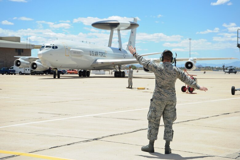 U.S. Air Force Staff Sgt. Joshua Colter, 552nd Aircraft Maintenance Squadron electrical and environmental systems specialist, marshals an E-3 Airborne Warning and Control System aircraft at Davis-Monthan Air Force Base, Ariz., May 16, 2015. Eight AWACS arrived here due to tornado alerts in Oklahoma. (U.S. Air Force photo by Airman 1st Class Chris Massey/Released)