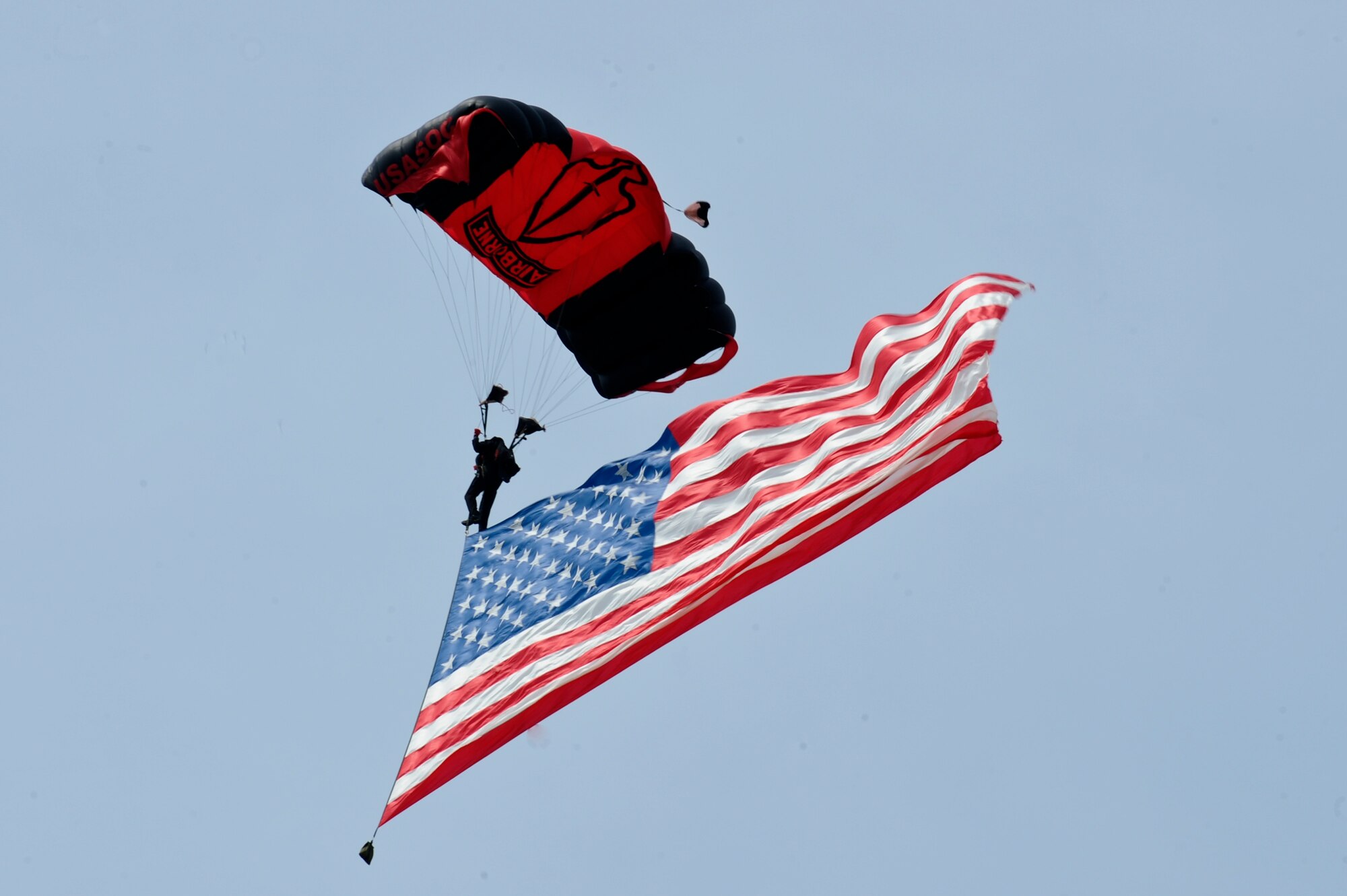 A member of the U.S. Army Black Daggers parachute demonstration team kicks off the 2015 Wings Over Wayne Airshow and Open House by dropping in with the American flag, May 16, 2015, at Seymour Johnson Air Force Base, North Carolina. The Black Daggers represent several different career fields and travel the country promoting community relations and showcasing the skill and dedication of U.S. Army Soldiers. (U.S. Air Force photo/Airman 1st Class Aaron Jenne)