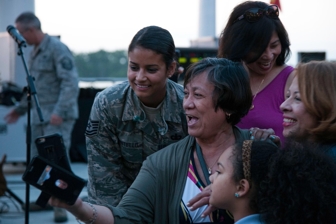 Tech. Sgt. Nalani Quintello, vocalist for the U.S. Air Force's premier rock band Max Impact, smiles while fans take a selfie with her after a performance at the National Harbor in Fort Washington, Md., May 15, 2015. It was Quintello’s debut performance as part of Max Impact. (U.S. Air Force photo/Airman 1st Class Philip Bryant)