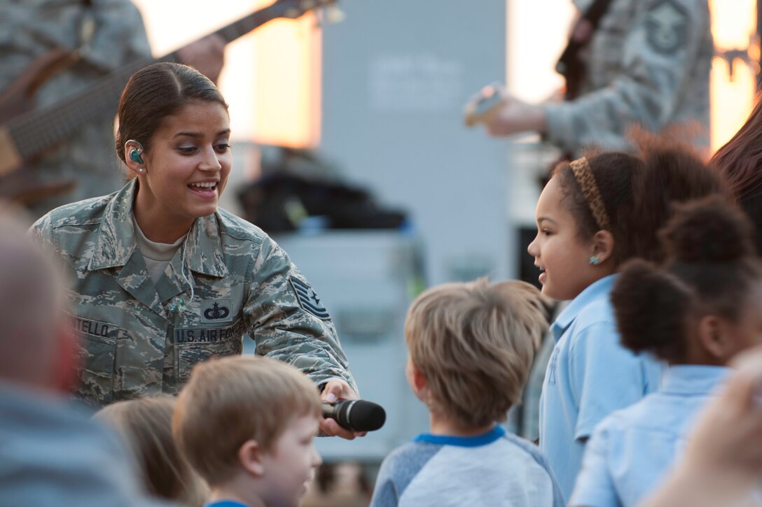 Tech. Sgt. Nalani Quintello, vocalist for the U.S. Air Force's premier rock band Max Impact, holds the microphone out for the audience to sing along at the National Harbor in Fort Washington, Md., as part of the Military Concert Series May 15, 2015. It was Quintello’s first public performance as part of Max Impact. (U.S. Air Force photo/Airman 1st Class Philip Bryant)