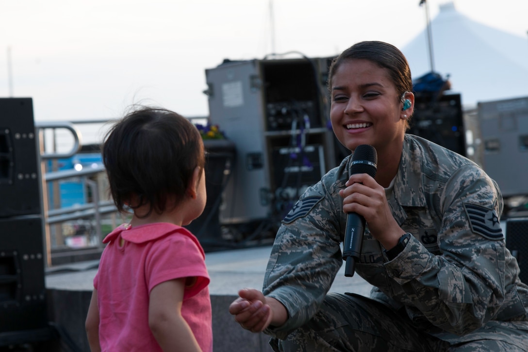 Tech. Sgt. Nalani Quintello, vocalist for the U.S. Air Force's premier rock band Max Impact, smiles while singing at the National Harbor in Fort Washington, Md., as part of the Military Concert Series May 15, 2015. It was Quintello’s first public performance as part of Max Impact. (U.S. Air Force photo/Airman 1st Class Philip Bryant)
