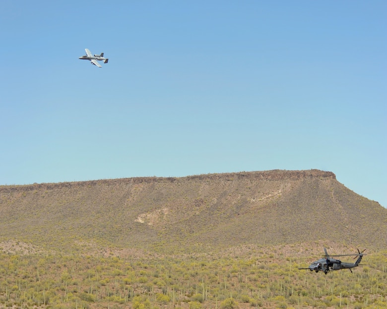 An A-10C Thunderbolt II, 357th Fighter Squadron, flies overhead providing rescue escort for a HH-60G Pave Hawk, Air Force Reserve 305th Rescue Squadron, during training at the Barry M. Goldwater Range, Ariz., April 22, 2015. The training allowed both units to achieve and maintain the capability to perform combat search and rescue missions together.  (U.S. Air Force photo by Airman 1st Class Chris Massey/Released)