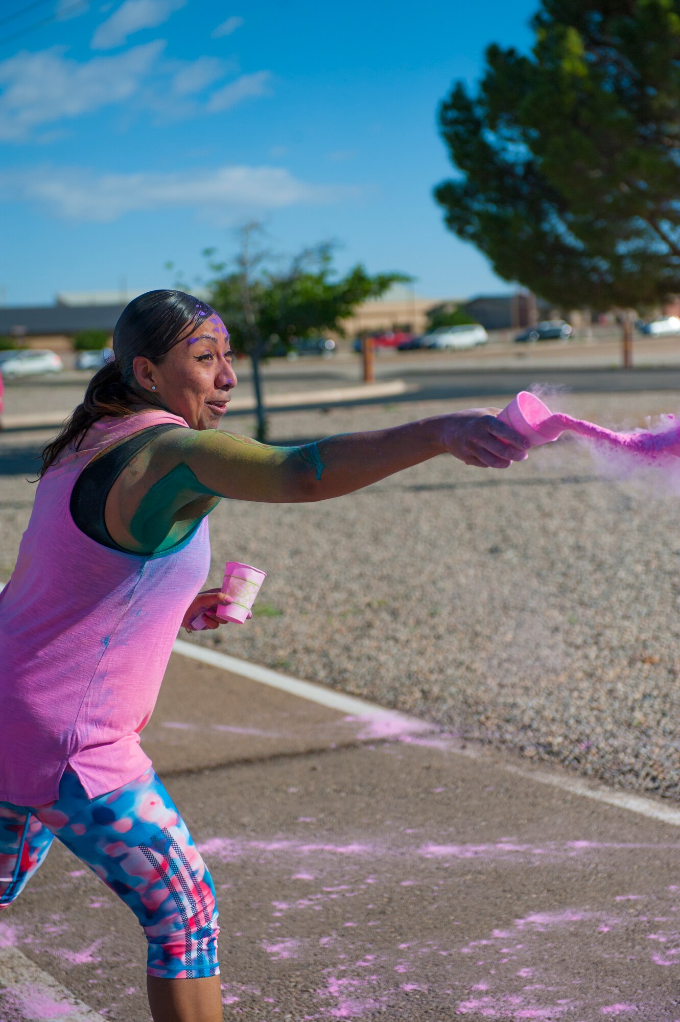 A member of the Domenici Fitness Center throws color onto runners during the Art Blast Color 5K Run at Holloman Air Force Base, N.M. May 16, 2015. The Fitness Center hosts monthly fun runs to help boost morale and get members of Team Holloman enthused about getting and staying fit. (U.S. Air Force photo by Senior Airman Leah Ferrante/Released)