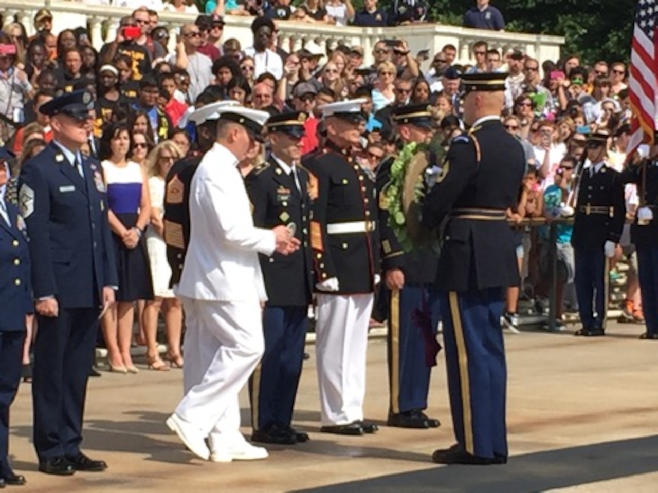 Master Chief Petty Officer of the Navy Michael Stevens steps forward to pin a medallion representing the Navy on a wreath honoring members of the armed forces during Armed Forces Day ceremonies at Arlington National Cemetery in Virginia, May 16, 2016. DoD photo by Shannon Collins