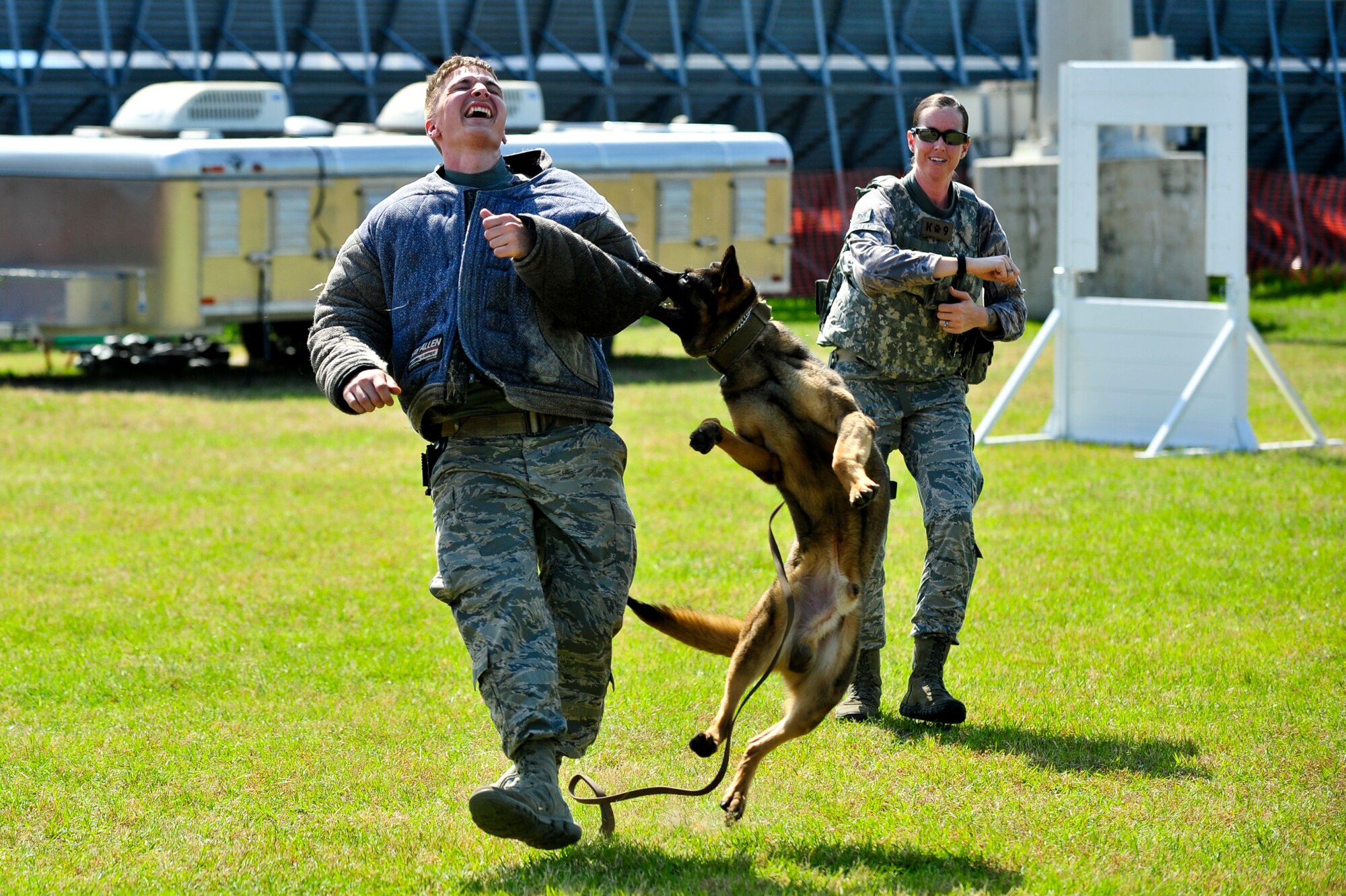 Staff Sgt. Nicole Gilley, 4th Security Forces Squadron military working dog handler, releases Kuli, 4th SFS MWD, to latch onto Senior Airman Zachary Byerly, 4th SFS MWD handler, during the 2015 Wings Over Wayne Airshow and Open House, May 17, 2015, at Seymour Johnson Air Force Base, North Carolina. MWDs complete rigorous training to prepare them for various tasks including search and rescue, detecting explosive materials, and maintaining the safety and security of their handlers and other personnel. (U.S. Air Force photo/Airman Shawna L. Keyes)