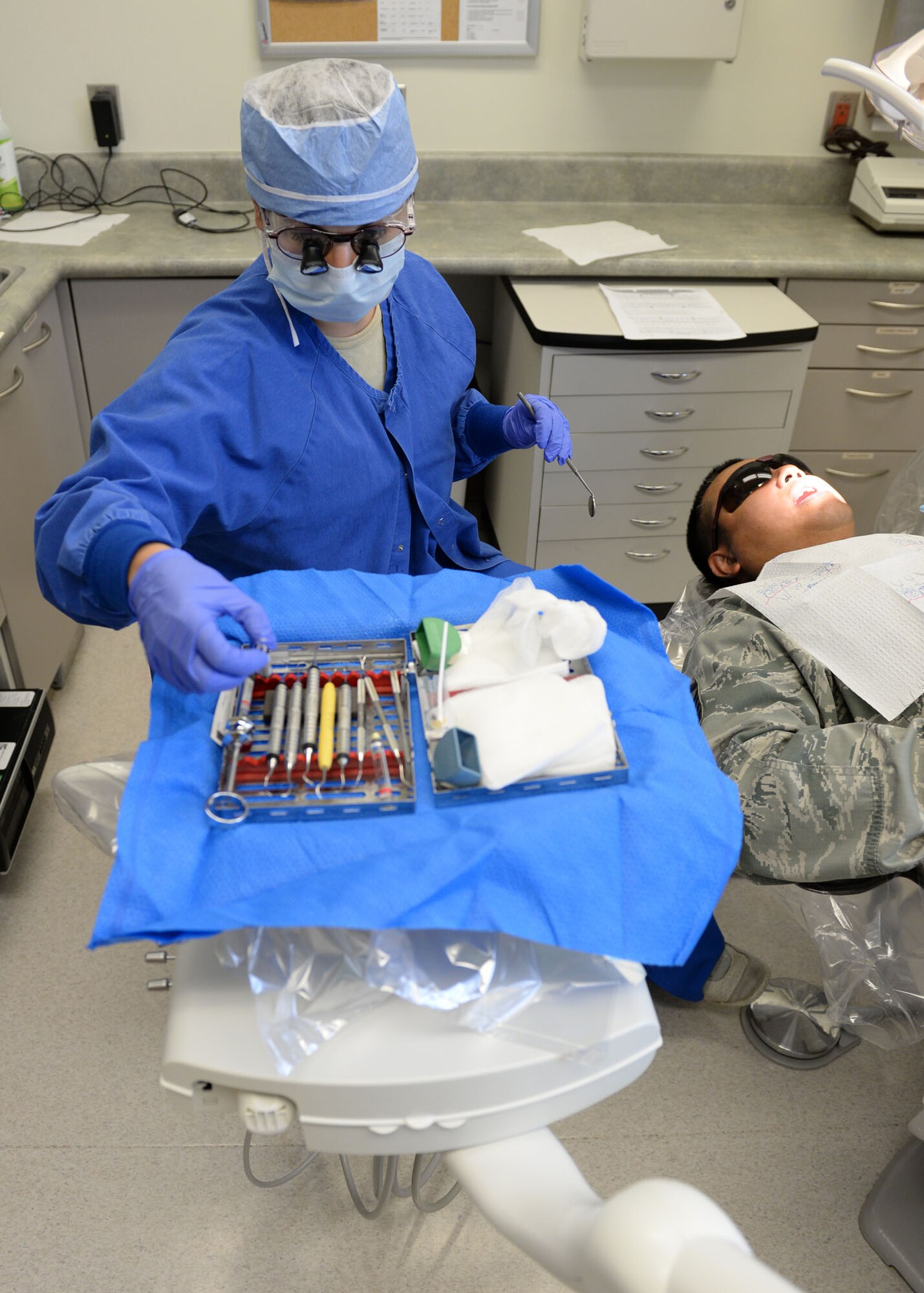 Capt. (Dr.) Nicole Catarino, 36th Medical Operations Squadron general dentist, grabs a tool during a scaling and root planing treatment May 11, 2015, at Andersen Air Force Base, Guam. The team of 18 dentists and technicians work together to ensure every active duty member at Andersen AFB has a fresh smile. (U.S. Air Force photo by Airman 1st Class Joshua Smoot/Released)
