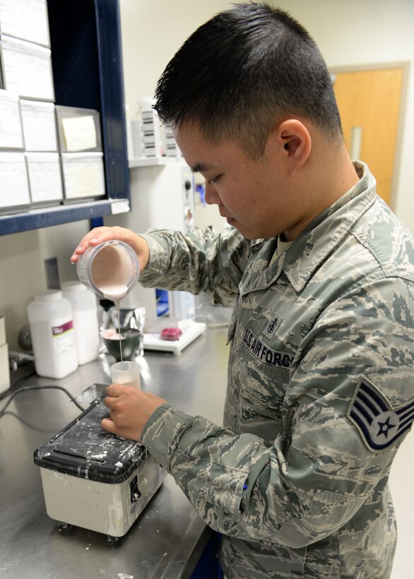 Staff Sgt. Yuxiong Liang, 36th Medical Operations Squadron dental lab technician, pours investment, or liquid stone, at a slow pace to let air out to ensure bubbles aren’t trapped in a final crown mold May 11, 2015, at Andersen Air Force Base, Guam. The dental clinic here consists of three elements – support, clinical and a dental lab. (U.S. Air Force photo by Airman 1st Class Joshua Smoot/Released)
