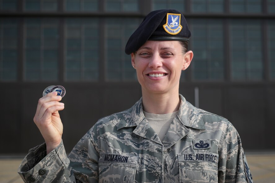 Master Sgt. Olivia McMahon holds up coins presented to her by Col. Robert Meyer, 108th Wing Commander and Chief Master Sgt. Daryl Fortner, 108th Wing Command Chief on May 17, 2015. McMahon was lauded for her outstanding performance as a Security Forces Squad Leader. (U.S. Air National Guard photo by Tech. Sgt. Matt Hecht)
