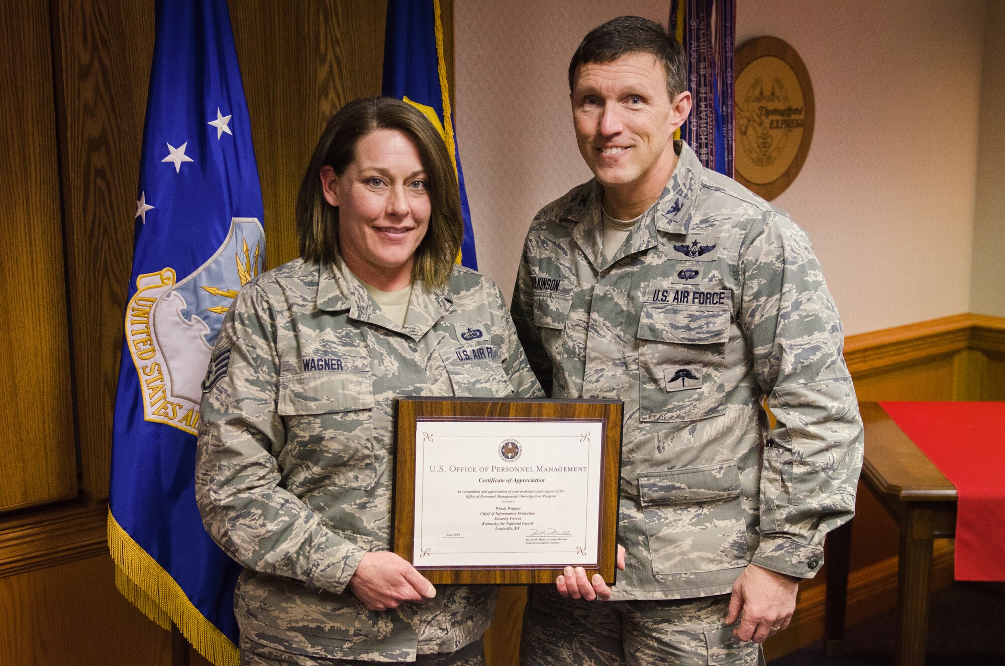 Col. Jeff Wilkinson, vice commander of the 123rd Airlift Wing, presents a certificate of recognition to Staff Sgt. Windy Wagner, chief of information protection, at the Kentucky Air National Guard Base in Louisville, Ky., Jan 8, 2015. Wagner was recognized for providing outstanding support to the U.S. Office of Personnel Management in its execution of security clearance investigations. (U.S. Air National Guard photo by Master Sgt. Phil Speck)