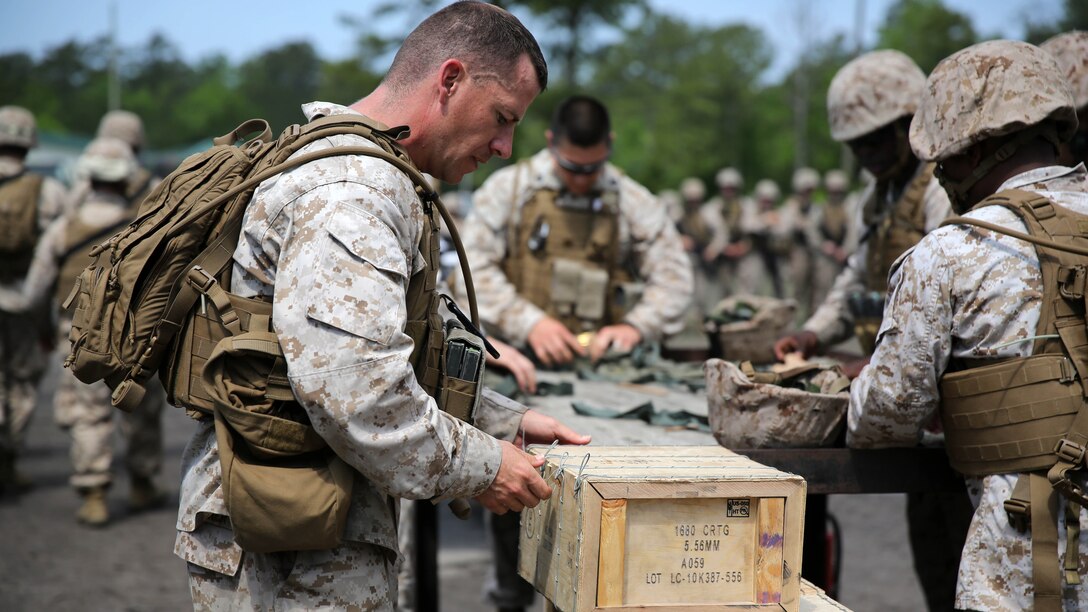 Gunny Sgt. Joshua Turner opens boxed ammunition during training at Marine Corps Base Camp Lejeune, North Carolina, May 13,2015.The training exercise focused on Marine Wing Communications Squadron 28's ability to build and maintain a communications network while in a field environment. Turner in the radio chief with MWCS-28.