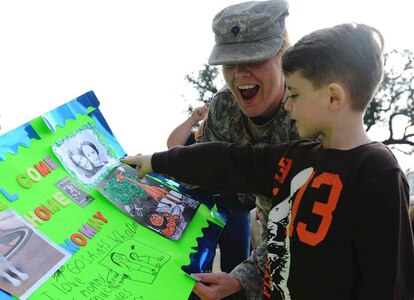 Army Spc. Crystal Houston, a Louisiana National Guardsman, looks at a colorful sign her 6-year-old son, Micah, created for her as she returns home from Iraq to Jackson Barracks, New Orleans, Dec. 22, 2010.  The 256th Infantry Brigade Combat Team completed a 365-day deployment in support of Operation Iraqi Freedom and Operation New Dawn.