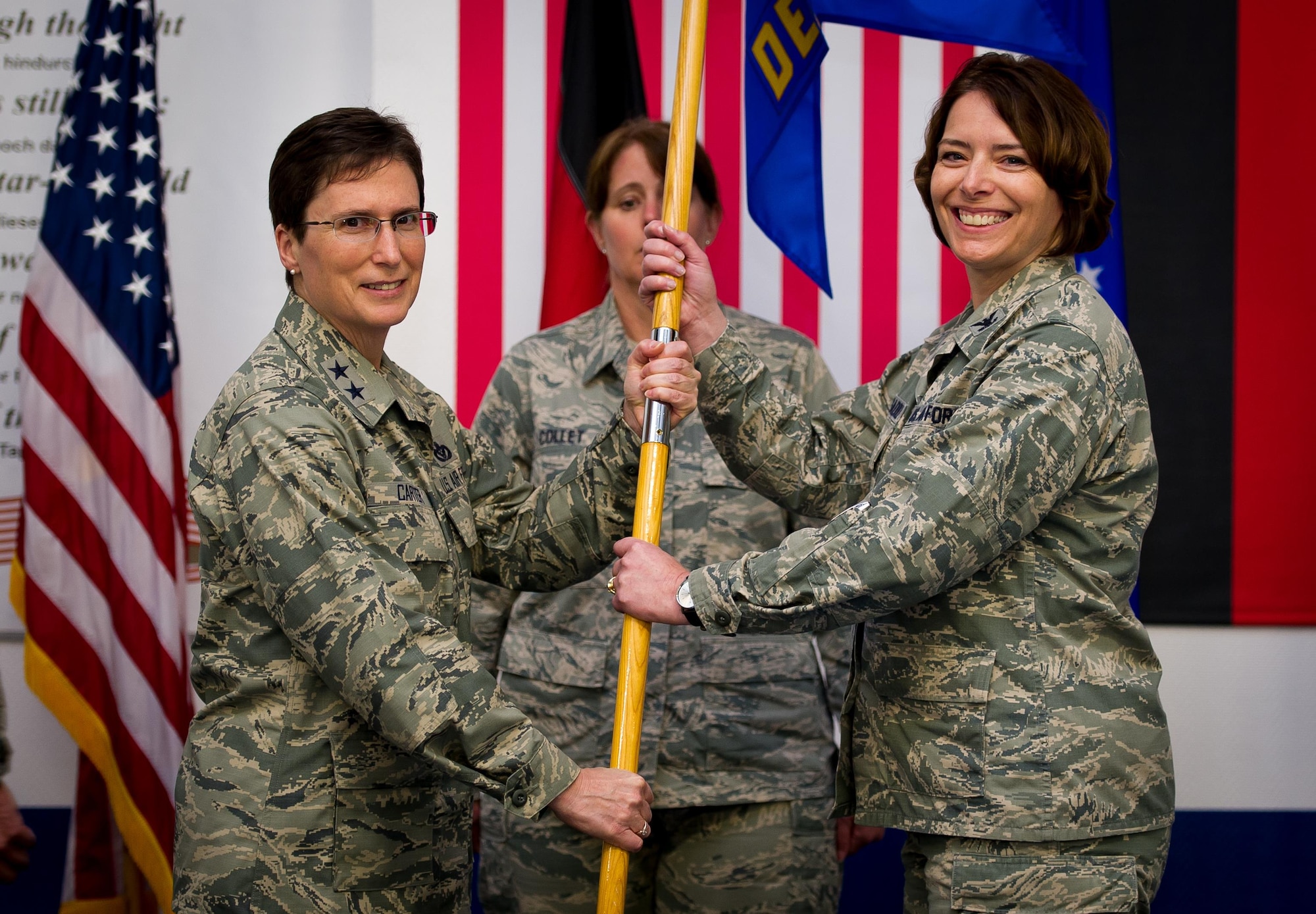 Maj. Gen. Theresa Carter, the Air Force Installation and Mission Support Center commander, passes the AFIMSC Detachment 4 flag to Col. Andra Clapsaddle, the AFIMSC Detachment 4 commander, during an assumption of command ceremony May 15, 2015, at Ramstein Air Base, Germany. AFIMSC is establishing detachments at each major command in order to best support the needs the management and operation of its installations while leveraging centralized capabilities in the AFIMSC headquarters, its six primary subordinate units and two direct reporting units (U.S. Air Force photo/Tech. Sgt. Ryan Crane)