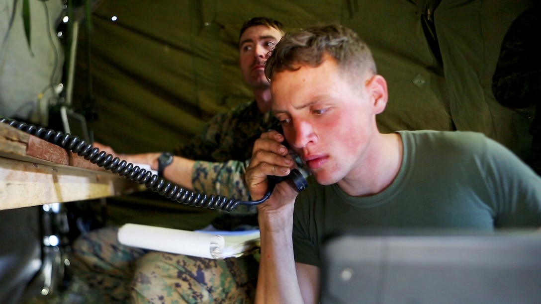 Cpl. William Thornton, (front), a forward observer, and Capt. Aaron Tyler, a joint terminal air controller, both with 1st Air Naval Gunfire Liaison Company, pass and receive key information during a key operation of Exercise Maple Resolve 2015 aboard Canadian Manoeuvre Training Center, Camp Wainwright, Alberta, May 10, 2015. The multi-national exercise, conducted annually by the Canadian Army, is a three-week high-readiness validation exercise for Canadian Army elements designated for domestic or international operations. This year, the 1st Canadian Army Division and the 5th Canadian Mechanized Battle Group are being supported by the British 12th Armoured Infantry Brigade, various U.S. Army elements, and for the first time, members of  I MEF’s 1st ANGLICO who bring a unique capability to the table.