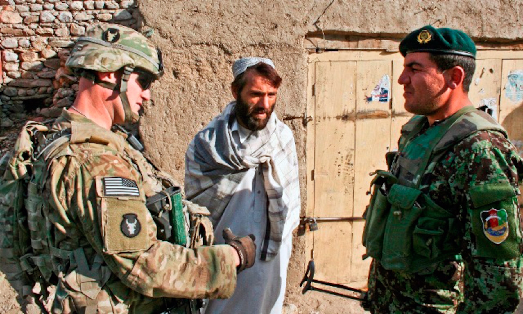 Army 1st Lt. John Dundee (left), 1st platoon leader for Company A, 1st Battalion, 133rd Infantry Regiment, and Afghan National Army Lt. Rastum (right), 1st Company, 1st Battalion, 201st ANA Regt., talk with a citizen of Ghaziabad Dec. 26.