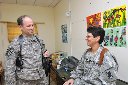 Massachusetts Army National Guard Maj. Martin Lesser, field surgeon with the 224th Sustainment Brigade, 103rd Sustainment Command (Expeditionary), speaks with his patient, Army Sgt. Bobbi Pizur, operations noncommissioned officer with the 319th Transportation Company, 110th Combat Sustainment Support Battalion, 224th Sustainment Brigade, and a Little Rock, Ark., native, at the troop medical clinic Dec. 22, 2010, at Contingency Operating Base Adder, Iraq. Lesser, 58, took a leave of absence at his private practice to serve here.