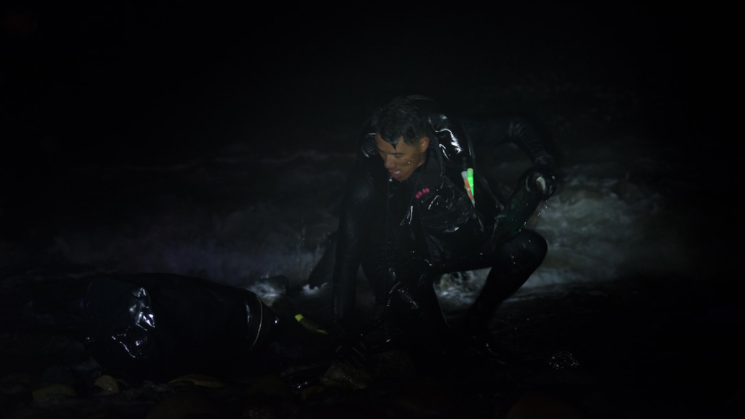 A reconnaissance Marine picks up his pack and transitions out of the water after a 1000-meter swim with fins during the Recon Challenge at San Onofre Beach, Marine Corps Base Camp Pendleton, California, May 15, 2015. The Recon Challenge is an annual competition of grueling tests, hosted by the Reconnaissance Training Company, Advanced Infantry Training Battalion, School of Infantry West, and conducted by volunteers from the recon community in honor of reconnaissance Marines and sailors killed in action.