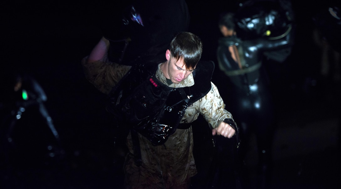 A reconnaissance Marine picks up his pack and transitions out of the water after a 1000-meter swim with fins during the Recon Challenge at San Onofre Beach, Marine Corps Base Camp Pendleton, California, May 15, 2015. The Recon Challenge is an annual competition of grueling tests, hosted by the Reconnaissance Training Company, Advanced Infantry Training Battalion, School of Infantry West, and conducted by volunteers from the recon community in honor of reconnaissance Marines and sailors killed in action.