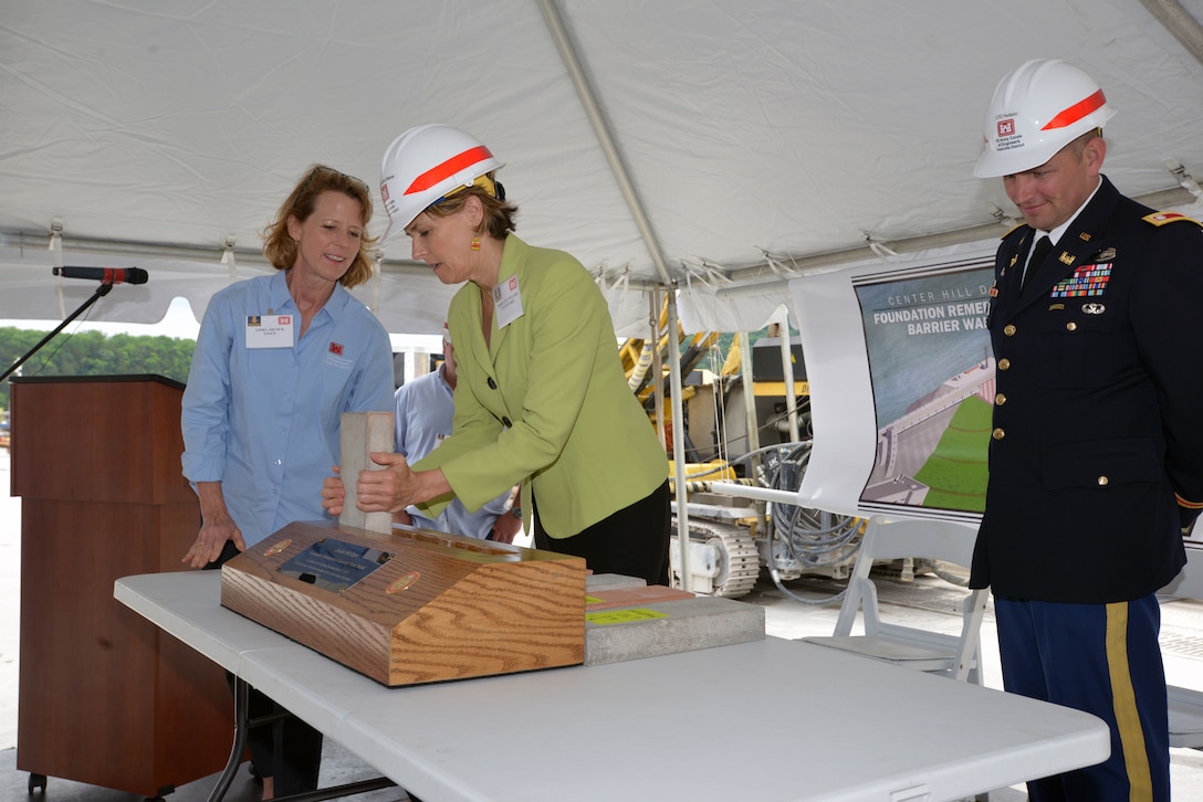 Linda Adcock (Left), U.S. Army Corps of Engineers Nashville District Center Hill Dam Safety project manager assists Tennessee State Rep. Terri Lynn Weaver place a ceremonial concrete form into a small-scale model commemorating the completion of the Center Hill Dam Barrier Wall Project May 18, 2015 on the work platform of the dam.  
