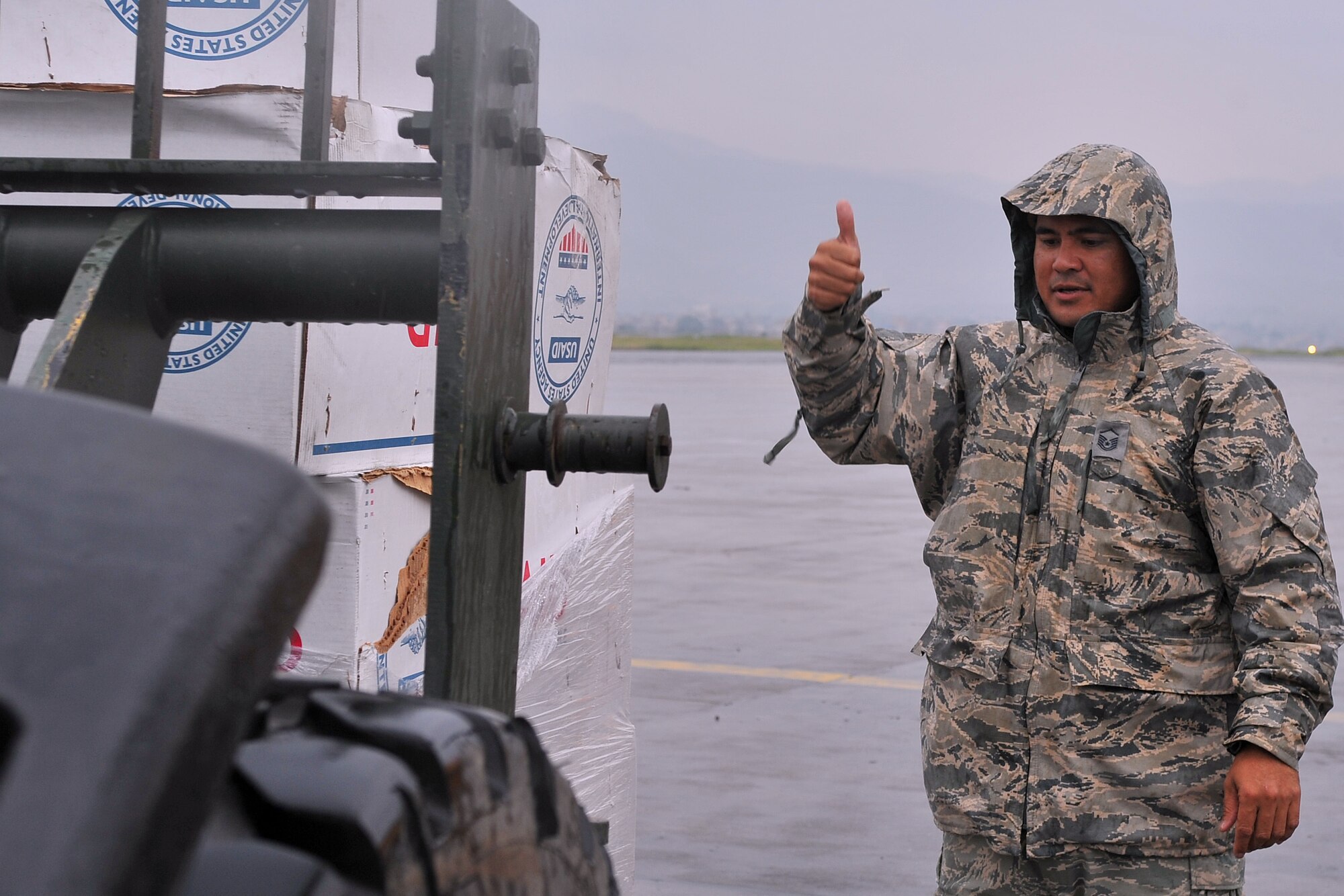 U.S. Air Force Master Sgt. Joe Damian, 36th Contingency Response Group independent duty medical technician-paramedic, guides an Airman using a forklift to download relief supplies from an aircraft at the Tribhuvan International Airport in Kathmandu, Nepal, May 16, 2015. Damian flew on nine sorties in three days with U.S. Marines in support of Operation Sahayogi Haat and transported a total of six patients following the second earthquake that struck Nepal May 12, 2015. (U.S. Air Force photo by Staff Sgt. Melissa B. White/Released)