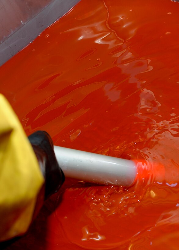 Airman 1st Class Royston Bedminster, 28th Maintenance Squadron nondestructive inspection technician, immerses part of an actuator into hydrophilic remover fluid during a nondestructive inspection process at Ellsworth Air Force Base, S.D., May 8, 2015. The fluid removes any excess penetrant from the part’s surface to prevent false indication readings during inspection. (U.S. Air Force photo by Senior Airman Anania Tekurio/Released)