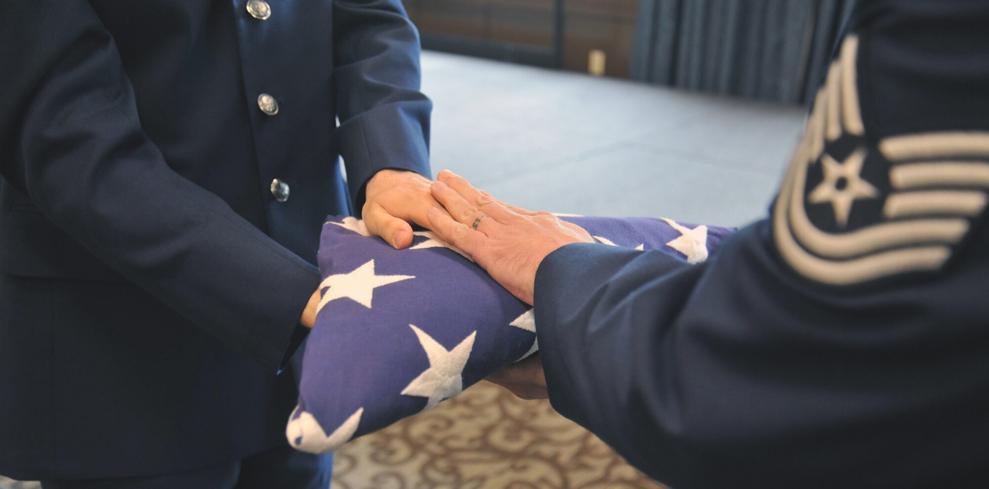 Staff Sgt. Spencer Browand, 92nd Maintenance Squadron aircraft fuel systems craftsman, hands off the flag to Tech. Sgt. Aaron Ramos, 92nd Aircraft Maintenance Squadron electrical environmental craftsman, during their Honor Guard graduation May 15, 2015, in the Red Morgan Center at Fairchild Air Force Base, Wash. During the honors of a funeral service of a fallen veteran, the flag is folded in honor of the deceased and is presented to the next-of-kin. (U.S. Air Force photo/Staff Sgt. Samantha Krolikowski) 