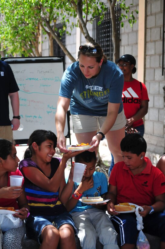 U.S. Air Force Capt. Laura Miller, Joint Task Force-Bravo adjutant, serves food to a group of children from the Saint Anthony of Padua Boys Home, as well as neighborhood children, outside La Paz, Honduras May 16, 2015. The 1st Battalion, 228th Aviation Regiment from Soto Cano Air Base leads monthly visits to local orphanages around Soto Cano Air Base, to serve the community. (U.S. Air Force photo by Capt. Christopher Love)