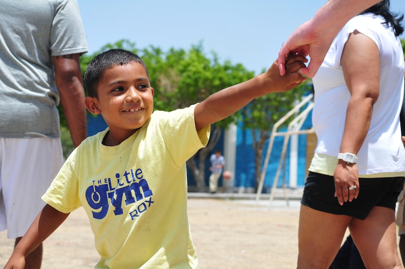 A boy tugs playfully on the hand of a volunteer from Joint Task Force-Bravo during a visit sponsored by the 1st Battalion, 228th Aviation Regiment to the Saint Anthony of Padua Boys Home outside La Paz, Honduras May 16, 2015. The 1-228 leads monthly visits to local orphanages around Soto Cano Air Base, to serve the community. (U.S. Air Force photo by Capt. Christopher Love)