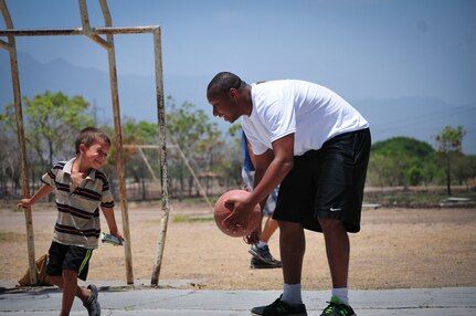 U.S. Air Force Staff Sgt. Shawn Gregoire, 612th Air Base Squadron noncommissioned officer in charge of transient alert, plays basketball with a boy from the Saint Anthony of Padua Boys Home outside La Paz, Honduras May 16, 2015. Gregoire volunteered his Saturday morning to spend time with the orphans there. (U.S. Air Force photo by Capt. Christopher Love)