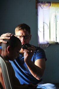 Chief Warrant Officer Dan Keslar, 1st Battalion, 228th Aviation Regiment CH-47 “Chinook” pilot, gives a haircut to a boy from the Saint Anthony of Padua Boys Home outside La Paz, Honduras May 16, 2015. A regular volunteer, Keslar offers haircuts as part of the 1-228’s monthly visits to local orphanages. (U.S. Air Force photo by Capt. Christopher Love)